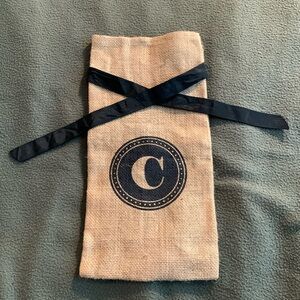 Monogram “C” burlap wine bag with black ribbon tie. Approximately 6 1/2” x 13”